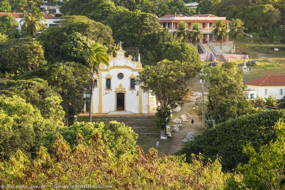 Imagem de uma igreja no meio das árvores na Vila dos Remédios.